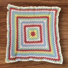 a crocheted square on top of a wooden table