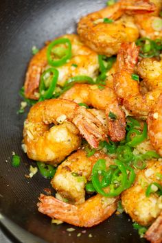 shrimp and green peppers in a skillet with seasoning on the side, ready to be cooked