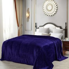 a bed with a purple blanket on top of it