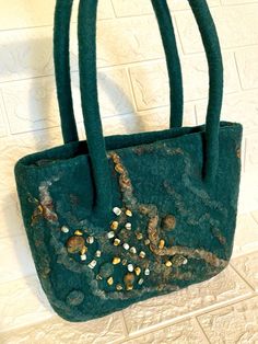 Bag felt made of 100%  wool , hand made . There lining with a zipper pocket .  Size ( 28 * 25 cm)   11*10 inch handle length 40-50 cm 100 % Wool , silk fiber , nettle , flax .  Handbag is combined with any fall or winter clothing. The bag is very easy. You can pin the flower and it will be a summer version of a handbag. This fashionable and stylish bag gives you individuality and  uniqueness Gift idea for her You can view other items in my store https://www.etsy.com/shop/makoshawool I ship your order within 1-3 business days after payment is confirmed. I use Etsy address, please make sure that it is correct. I will tell you the track number for tracking parcel. Standard international shipping takes up to 20 business days and accept through Ukrposhta.  In connection with the epidemic in the Handmade Green Bag For Gift, Green Handmade Tote Shoulder Bag, Handmade Green Tote Shoulder Bag, Green Tote Shoulder Bag As Gift, Handmade Green Shoulder Bag For Shopping, Handmade Felt Bag For Daily Use, Rectangular Felt Bags For Gifts, Rectangular Felt Bags As Gifts, Silk Fiber