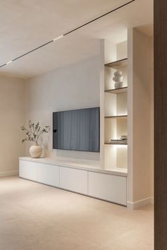 a living room with a large flat screen tv on top of a white entertainment center