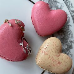 two heart shaped pastries sitting on top of a white plate next to each other