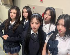 several girls in school uniforms posing for the camera