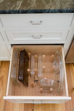 an open drawer in a kitchen with wooden flooring