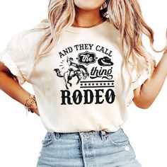 Celebrate your love for rodeo and country life with our Comfort Colors® shirt that proudly displays the phrase "And They Call The Thing Rodeo." Perfect for casual outings, country music festivals, and everyday wear. Features: - 100% ring-spun cotton - Pre-shrunk, soft-washed, garment-dyed fabric - Double-needle stitched sleeves and bottom hem for added durability - Relaxed fit for all-day comfort - Available in the stylish Pepper and Ivory colors Why You'll Love It: - Soft, high-quality fabric f Cotton Rodeo Shirt With Letter Print, Western Letter Print Tops For Country Events, Western Tops With Letter Print For Country Events, Cotton Shirt With Letter Print For Rodeo, Western Style Top With Letter Print For Country Events, Western Style Tops With Letter Print For Country Events, Crew Neck Letter Print Shirt For Rodeo, Country Style Cotton Tops With Letter Print, Country Music Festival