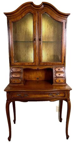 an old wooden desk with glass doors and drawers