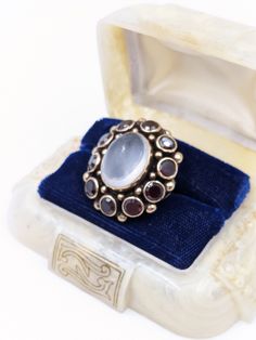 "Antique Moonstone Ring, Victorian 14k Gold Moonstone Garnet Ring, Georgian Large Oval Moonstone Garnet Ring, Garnet Moonstone Cluster Ring in a size 6 and sizable. An amazing huge Antique 14k Gold statement ring with a large center genuine Moonstone that is approximately 13.5ctw & measures 16mm x 12mm surrounded by 10 round genuine Garnet gemstones that are approximately 6.5ctw & 5mm diameter each. Total gemstone weight of 20ctw of Antique genuine gemstones in this fabulous ring! The ge Collectible Oval Rings With Gemstone Accents, Heirloom Oval Moonstone Ring, Oval White Ruby Ring, Antique Oval Cabochon Moonstone Ring For Formal Occasions, Heirloom Oval Cabochon Moonstone Ring, Victorian Moonstone Ring For Anniversary, Heirloom Moonstone Oval Cabochon Ring For Formal Events, Antique Oval Moonstone Ring For Anniversary, Heirloom Oval Cabochon Moonstone Ring For Formal Occasions