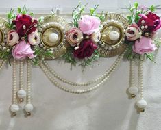 a wall hanging with flowers and pearls on it