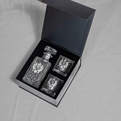 an open box with three empty glass bottles in it on a white tablecloth background