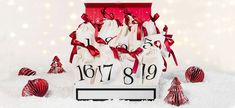 a red and white gift bag sitting on top of a pile of snow covered ground