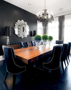 an image of a dining room table with chairs and chandelier in the background