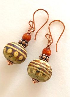 Stunning artisan lampwork rondelle bead earrings in caramel, taupe, and coppery gold swirl design accented with rustic orange fire agates and copper beads. These gorgeous handmade large rondelle beads are 11 x 15mm with smooth matte finish. Slivers of glass and fine silver are used to “draw” intricate designs before beads are kiln fired at +900 degrees. The result is a beautiful unique one of a kind lampwork bead. I have matched colors and patterns as closely as possible but no two are alike. Th Jewelry Video, Red Sea Glass, Rustic Orange, Bohemian Style Jewelry, Lampwork Earring, Boho Handmade, Sea Glass Earrings, Pumpkin Earrings, Fall Earrings