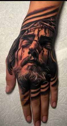 a man's hand with a tattoo on it that has an image of jesus