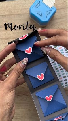 two hands holding an open envelope with hearts on it and the words morta above it