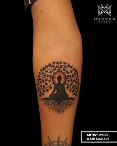 a woman's leg with a tattoo on it that has a buddha sitting in the middle