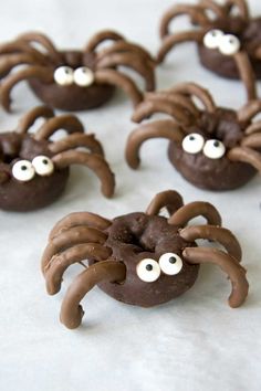 chocolate spider cookies with googly eyes on white paper