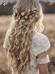 the back of a woman's head with long hair and flowers in her hair