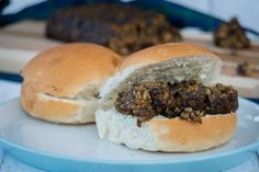 a close up of a sandwich on a plate with meat in the middle and bread crumbs around it