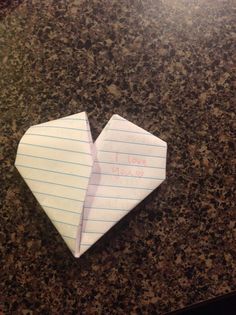 an origami heart shaped piece of paper with writing on it