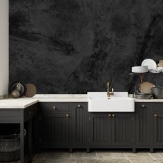 a black and white kitchen with marble counter tops, sink and cabinets in front of the wall