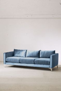 a blue couch sitting on top of a wooden floor