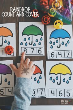 a child's hand is pointing at the raindrop count and cover game