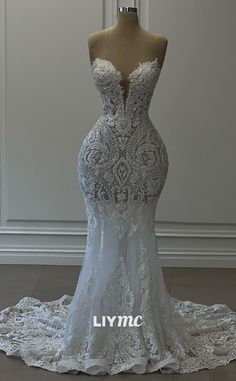 a wedding dress on display in front of a white wall