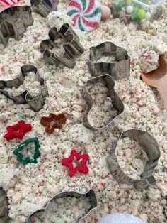 several cookie cutters are laying on the ground with candy canes and candies