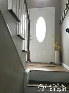 stairs leading up to a white front door with an arched glass window on the side