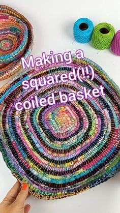 someone is making a square quilted basket with yarn and thread on the table next to it