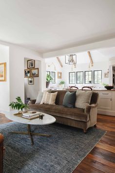 a living room filled with furniture and a large rug on top of a hard wood floor