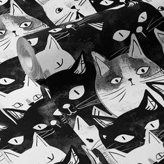 a roll of black and white cat wrapping paper on top of a table with scissors