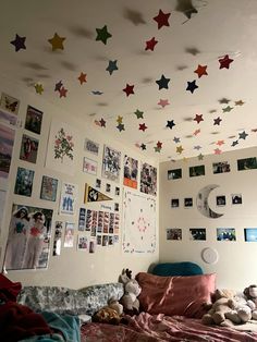 a bed room with a neatly made bed and lots of pictures on the wall above it