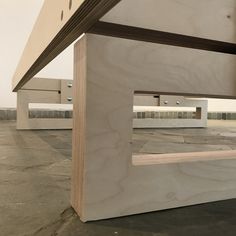 an empty parking lot with benches and tables in the background, some are made out of plywood