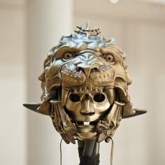 a golden mask with horns and spikes on it's head