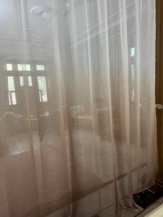 an open window with sheer curtains in a room that has no one inside or outside