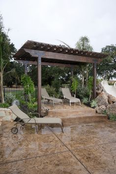 a patio with lounge chairs and a pergolated area