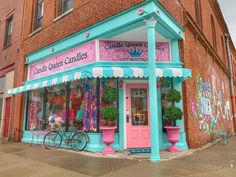 a pink and blue store front with bicycles parked outside