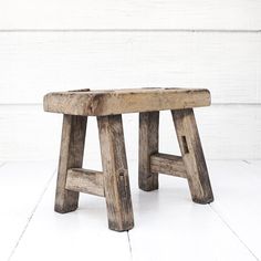 a wooden bench sitting on top of a white floor