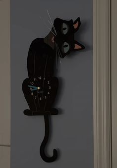 a clock with a black cat on it's face is hanging from the wall