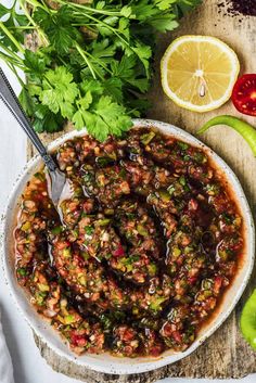 a bowl filled with beans and vegetables next to sliced limes