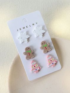 three pairs of earrings are shown on a white plate with snowflakes in the background