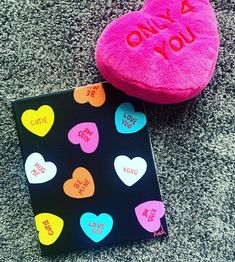 two heart shaped cushions sitting on the floor next to each other with i love you written on them