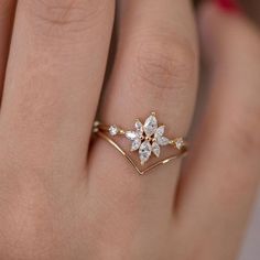 a woman's hand with a diamond ring on top of her finger and the other hand holding it