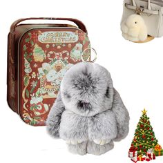 a stuffed animal sitting next to a christmas tree and suitcase with decorations on the side