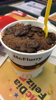 an ice cream sundae with chocolate chips and a yellow straw