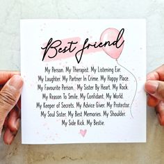 two hands holding up a card with the words best friend written in black on it