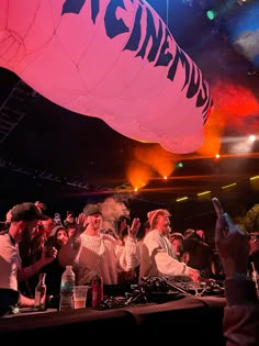 a group of people sitting at a table in front of a giant hot air balloon