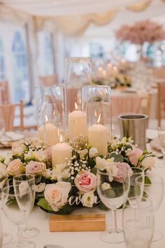 a centerpiece with flowers and candles on a table