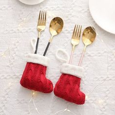 two knitted christmas stockings with gold forks and spoons